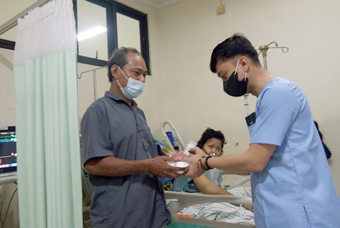 SALING BANTU: Pegawai RSUD dr. Loekmono Hadi Kudus membagi takjil kepada penunggu pasien kelas III kemarin. (INDAH SUSANTI/RADAR KUDUS)
