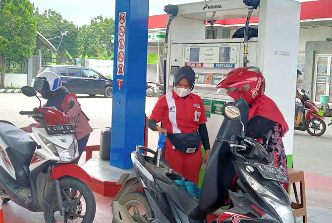 ANTRE: Petugas sedang mengisikan pertamax ke pelanggan di salah satu SPBU kemarin. (AHMAD ZA’IIMUL CHANIEF/RADAR KUDUS)