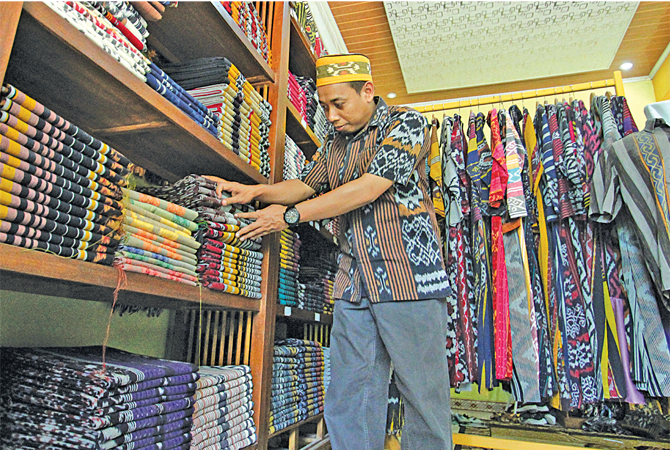 RAPI: Ratusan kain tenun beragam motif tertata dalam sebuah rak di workshop Mitra Warna milik Irbab. (MOH. NUR SYAHRI MUHARROM/RADAR KUDUS)