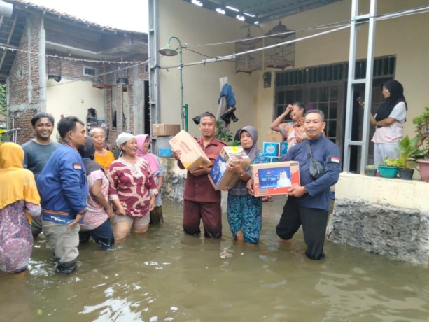 PEDULI BENCANA: Anggota Komunitas Sahabat Lestari menyalurkan bantuan kepada korban rob di Demak. (SAHABAT LESTARI FOR RADAR KUDUS)