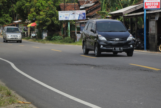 AMBLES: Pengendara melintas di jalan nasional Rembang - Blora  tepatnya di kecamatan Sulang yang mulai retak dan ambles sehingga menyebabkan jalan berayun kemarin. (WISNU AJI/RADAR KUDUS)