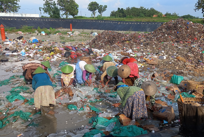 SERBU: Para pemungut sampah di TPA Blora berebut botol arak setelah dimusnahkan, Senin (23/5). (VACHRI RINALDY L/RADAR KUDUS)