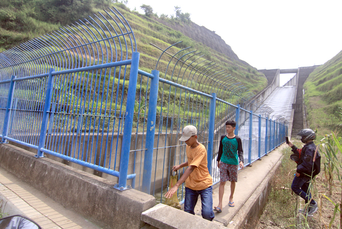 JAGA TETAP LANCAR: Petugas Waduk Logung membersihkan sampah di limpasan air Bendungan Logung kemarin. (DONNY SETYAWAN/ RADAR KUDUS)