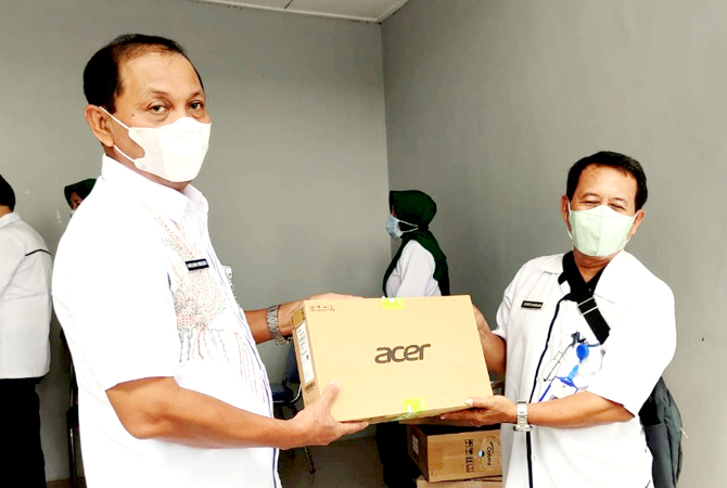 SERAH TERIMA: Kepala Disdikpora Kudus Harjuna Widada (kiri) menyerahkan laptop kepada koordinator wilayah Kaliwungu di aula kantor baru-baru ini. (INDAH SUSANTI/RADAR KUDUS)