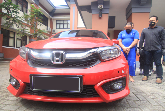 DITANGKAP DI KUDUS: Mobil Honda Brio merah milik korban penipuan dengan pelaku Agus Widjianto (kaus biru) yang mengaku sebagai anggota brimob. (DONNY SETYAWAN/RADAR KUDUS)
