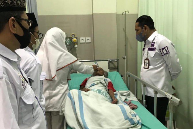 DAMPINGI: Camat Kaliwungu Kudus  Satria Agus Himawan mendampingi mbah Atemi mendapatkan perawatan di Rumah Sakit Islam Sunan Kudus. (DOK. RADAR KUDUS)