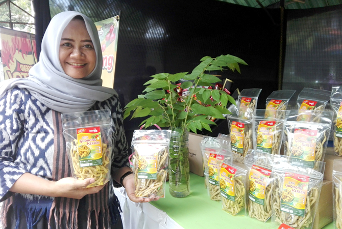 CAMILAN: Sashi Wulandari menunjukkan produk olahan stik daun kersen saa pergelaran UMKM. (ARIKA KHOIRIYA/RADAR KUDUS)