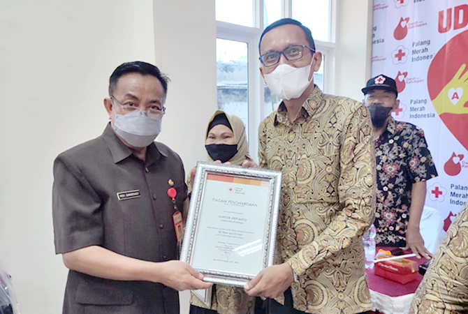 BERIKAN PENGHARGAAN: Ketua PMI Grobogan Sumarsono memberikan penghargaan kepada warga yang menjadi pendonor 50 kali dan 75 kali di kantor PMI setempat, kemarin. (SIROJUL MUNIR/RADAR KUDUS)