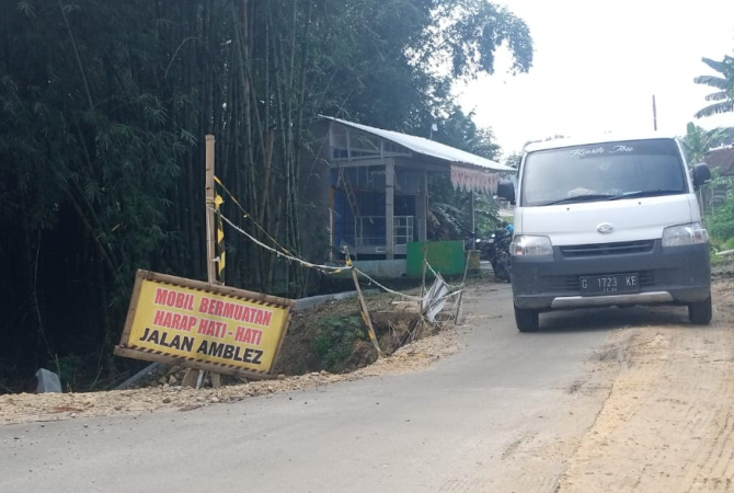 BAHAYA: Kendaraan yang melintas di Jalan yang ambles di Desa Ngrandah berhati-hati, Rabu (6/7). EKO SANTOSO/RADAR KUDUS