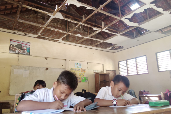 BAHAYA: Siswa kelas IV SD N I Katekan, Brati, Grobogan, tetap beraktivitas di bawah ruang kelas yang rusak, Selasa (12/7). (EKO SANTOSO/RADAR KUDUS)