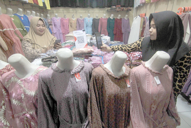 MODERN: Pedagang Pasar Kliwon gunakan QRIS untuk transaksi nontunai. (DONNY SETYAWAN/RADAR KUDUS)