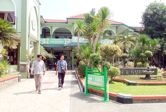 MADRASAH FAVORIT: Beberapa pengunjung tampak melewati area taman halaman depan MAN 2 Kudus belum lama ini. (ARIKA KHOIRIYA/RADAR KUDUS)