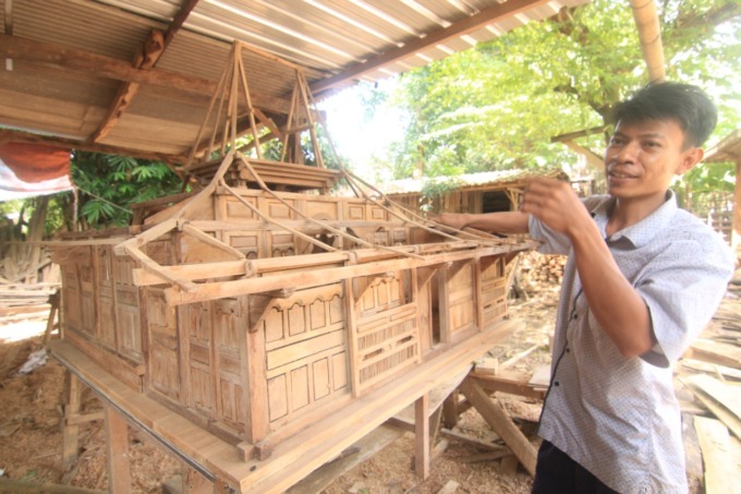 SENI NGURI-URI BUDAYA: Eko Nor Haris membuat ukiran Kudusan pada replika rumah adat Kudus Joglo Pencu baru-baru ini. (DONNY SETYAWAN/RADAR KUDUS)