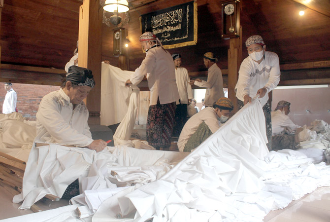 TRADISI TAHUNAN: Para rewang melepas luwur atau kain penutup makam Sunan Kudus kemarin. (GALIH ERLAMBANG W/RADAR KUDUS)
