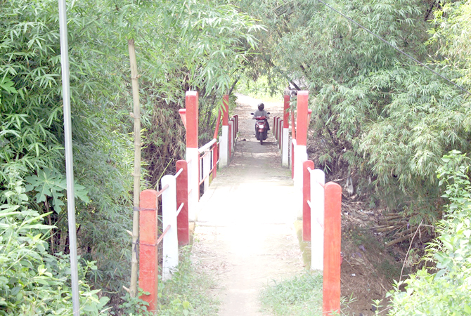 BERUBAH-UBAH: Warga melintasi jembatan makam Desa Pulo, Rembang. Daerah sekitar itu salah satu lokasi terkena perubahan kedua jalur tol. (WISNU AJI/RADAR KUDUS)