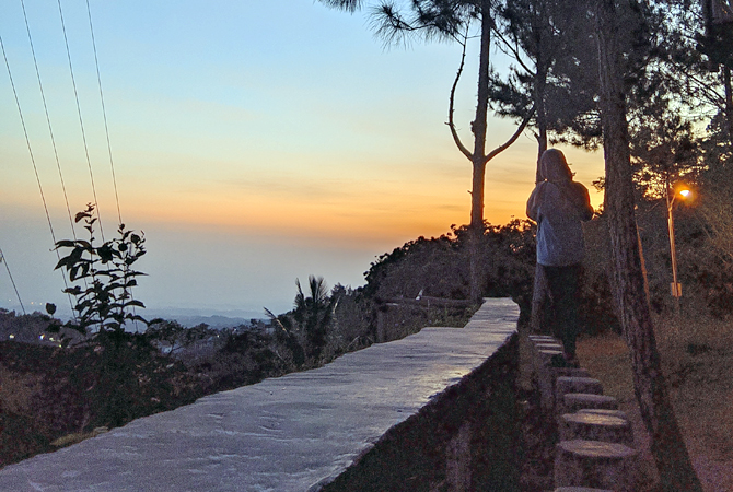 MENIKMATI SUNSET: Salah satu pengunjung menikmati senset di Bukit Sepuser pada Selasa (26/7) sore. Selain banyak fasilitas permainan, di Bukit Sepuser juga disediakan arena camping lengkap dengan fasilitas sewa tenda. (SELFA AYU FAUZUL MUNA FOR RADAR KUDU