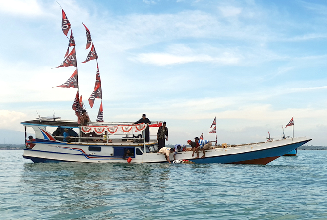 RITUAL: Warga Bondo, Bangsri melarung hasil bumi ke tengah laut kemarin. (NIBROS HASSANI/JAWA POS RADAR KUDUS)