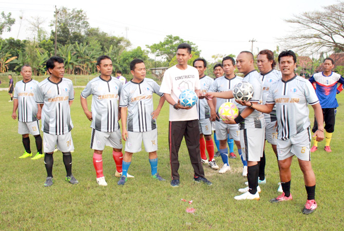SERAHKAN BOLA: Sunardi yang akrab Lek Di menyerahkan bantuan bola kepada Kepala Desa Wolo, Kecamatan Penawangan Suyantono sebagai pembina SSB Bintang Muda Wolo di lapangan Desa setempat, kemarin. (SIROJUL MUNIR/RADAR KUDUS)