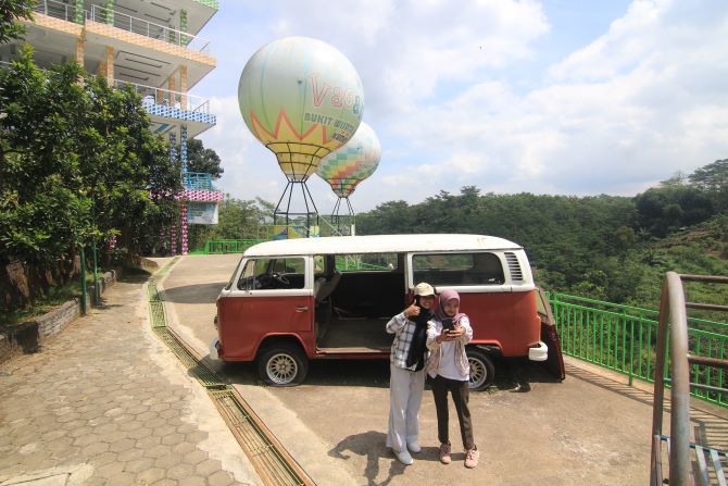 INSTAGRAMMABLE: Pengunjung swafoto dengan latar belakang balon udara di The Hills Vaganza Kudus. (DONNY SETYAWAN/RADAR KUDUS)