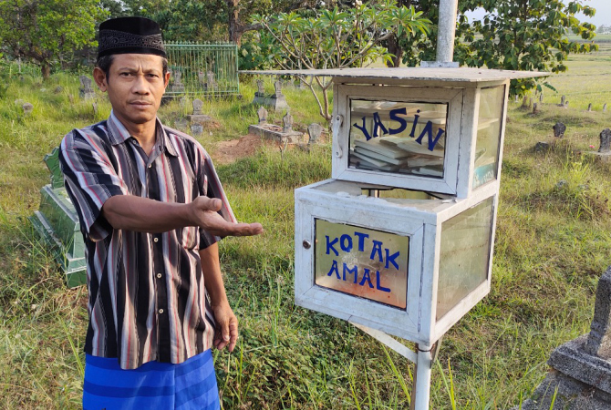 PECAH: Senen, Penjaga Makam Nolo Seto Dukuh Pudak, Desa Sarimulyo, Ngawen, menunjukkan kondisi kotak amal pascadibobol, Jumat (12/8). (AHMAD ZA’IIMUL CHANIEF/RADAR KUDUS)