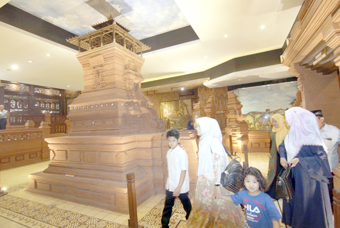 MUSEUM: Beberapa pengunjung saat melewati replika Menara Kudus yang berada di ruang tengah Museum Jenang. (DONNY SETYAWAN/RADAR KUDUS)