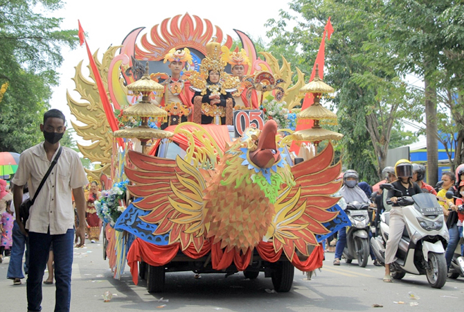 MOBIL GARUDA: Kepala SMPN 3 Rembang Menik Mustikatun (baju hitam depan) naik mobil hias saat Karnaval Pembangunan dan Kebangsaan kemarin. (WISNU AJI/RADAR KUDUS)