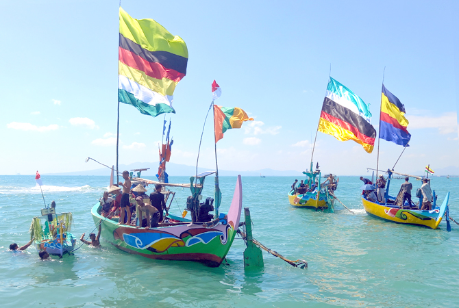 MENJAGA TRADISI: Warga Desa Gegunung Wetan, Rembang Kota, melaksankan prosesi larung sesaji di sekitar Pulau Masaran kemarin. (VACHRI RINALDY L/RADAR KUDUS)