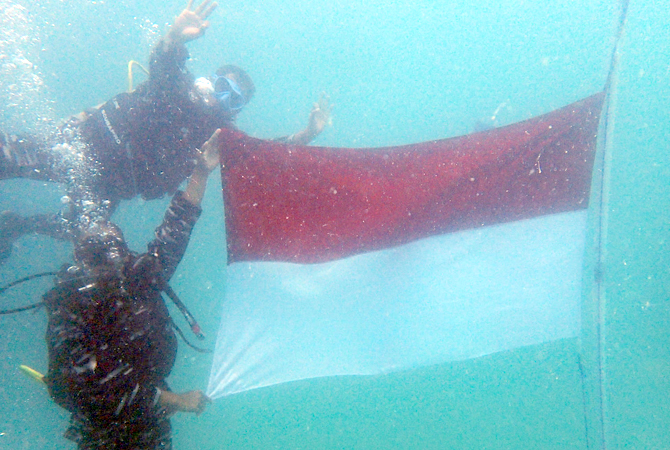 DIRGAHAYU: Penyelam TNI AL menggelar upacara bendera di dasar laut Karimunjawa dengan kedalaman 12 meter kemarin. (TNI AL FOR RADAR KUDUS)