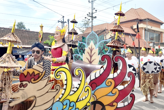 ATRAKTIF: Peserta festival kebudayaan Desa Rengging melintasi jalan raya untuk memperlihatkan tampilan kelompoknya, Minggu (15/8). (NIBROS HASSANI/JAWA POS RADAR KUDUS)