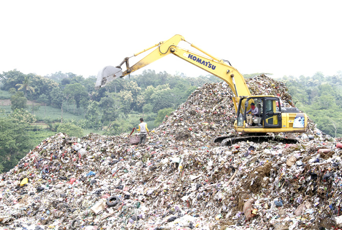KERUK SAMPAH: Petugas sedang mengerahkan alat berat untuk mengeruk sampah di Tempat Pembangunan Akhir (TPA) Tanjungrejo belum lama ini. (DONNY SETYAWAN/RADAR KUDUS)