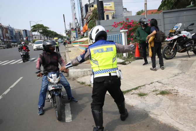 TILANG: Pengendara sepeda motor ditilang usai melakukan pelanggaran lalu lintas baru-baru ini. (JAWAPOS.COM)