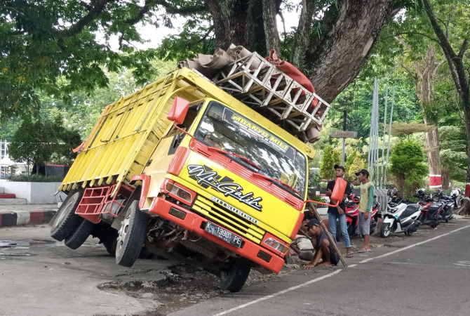 AMBLES: Truk pengangkut panggung acara HSN amblong di atas tutupan lubang drainase yang berada di kawasan alun-alun depan Pendopo kabupaten Grobogan, Senin (24/10). (EKO SANTOSO/RADAR KUDUS)
