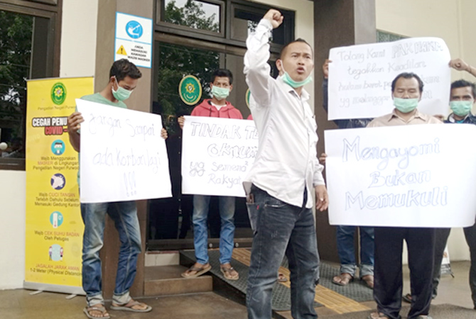 KEBERATAN: Ahmad Kholik bersama warga membawa spanduk keberatan atas putusan Pengadilan Negeri Purwodadi, kemarin. (EKO SANTOSO/RADAR KUDUS)