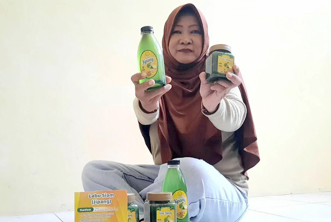 KREATIF: Lelasari bersama produk olahan labu siam berupa sirup dan selai di rumahnya kemarin. (INDAH SUSANTI/RADAR KUDUS)