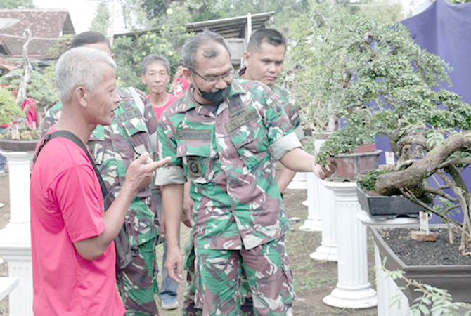 INDAH: Ketua Komunitas Bonsai (Koboi) Bambang Winarko bersama Danramil 06/Margoyoso Kapten Inf Jubaidi di area pameran bonsai di komplek mess Kodim 0718/Pati Jalan Kembangjoyo Desa Kutoharjo kemarin. (ACHMAD ULIL ALBAB/RADAR KUDUS)