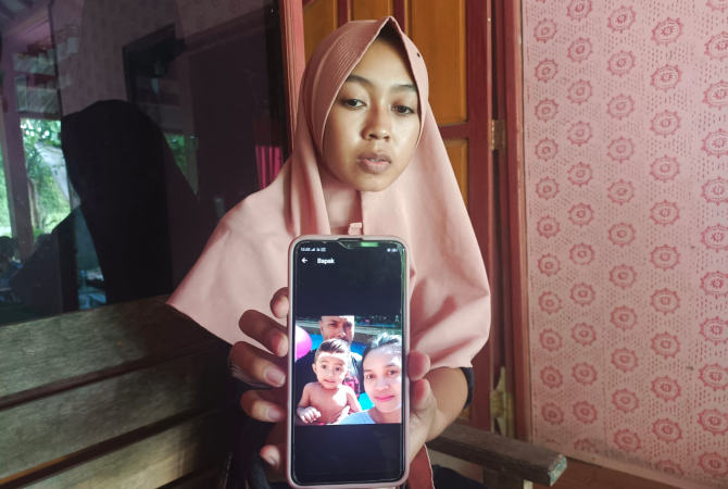 TUNJUKKAN: Anak sulung korban, Anis Sekar Arum saat menunjukkan foto ibu dan adiknya, Kamis (17/11). (PUJIYANTO FOR RADAR KUDUS)