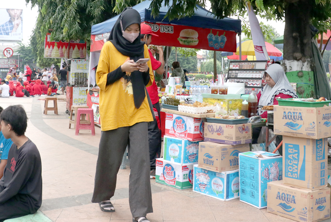 JUALAN DI ALUN-ALUN: Pedagang kaki lima disemprit karena berjualan di alun-alun Simpang Tujuh Kudus sehingga mengganggu aktivitas pejalan kaki yang berolahraga. (DONNY SETYAWAN/RADAR KUDUS)