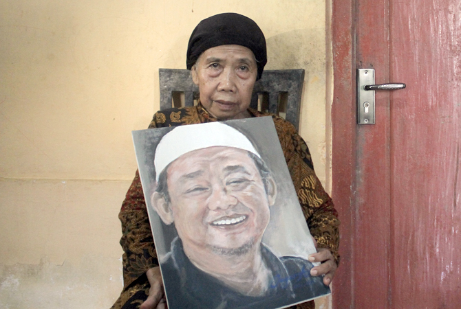 KEBANGGAAN ORTU: Hj Kartinah memegang lukisan wajah anaknya yang kini menjabat sebagai Sekretaris Umum PP Muhamadiyah Abdul Mu’ti. (GALIH ERLAMBANG W/RADAR KUDUS)