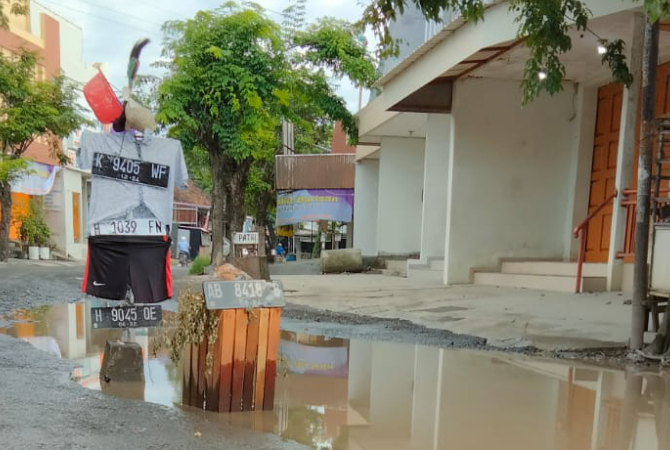 PARAH: Orang-orangan sawah dipasang warga di jalan Gubug-Kedungjati, Kamis (1/12). (JOKO FOR RADAR KUDUS)