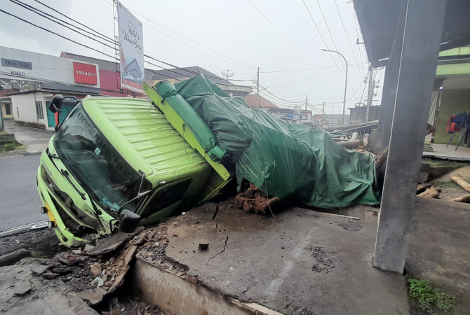 TABRAK: Truk pemuat kayu jati asal Tasikmalaya, Jawa Barat menabrak halaman rumah warga RT 04/RW 03 Desa Ngabul, Kecamatan Tahunan pada Minggu (25/12) sekira pukul 05.00. (NIBROS HASSANI/RADAR KUDUS)