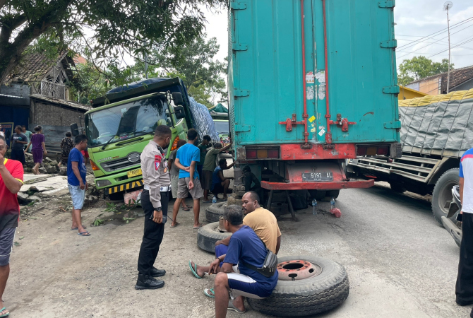 HAMBAT LALU LINTAS: Kasat Lantas Polres Blora AKP Noach Hendrik Daud (berseragam) meninjau lokasi tiga truk tronton rusak yang menutupi jalan pada Rabu (28/12). (SATLANTAS POLRES BLORA FOR RADAR KUDUS)