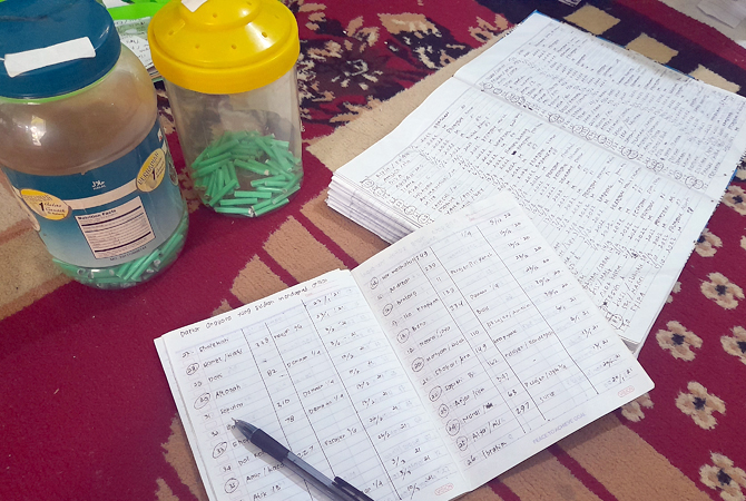 PENDATAAN: Beberapa buku dan undian nama yang mengikuti arisan bernilai Rp 3,9 miliar sedang didata oleh salah seorang warga kemarin. (NIBROS HASSANI/JAWA POS RADAR KUDUS)