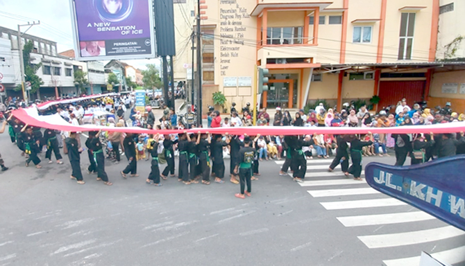 MERIAH: Para santri mengusung bendera Merah Putih sepanjang 800 meter saat kirab peringatan haul Habib Ja’far Al-Kaff dengan start di Jalan Pengeran Puger kemarin. (DONNY SETYAWAN/RADAR KUDUS)