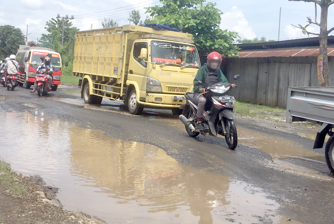 RUSAK: Pengguna jalan terlihat melintasi ruas jalan Desa Glonggong, Jakenan belum lama ini. (ANDRE FADHIL FALAH/RADAR KUDUS)
