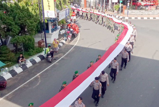 DIBENTANG: Bendera merah putih dikirab dari makam Pahlawan sampai Alun-alun Kudus kemarin. (ARIKA KHOIRIYA/RADAR KUDUS)