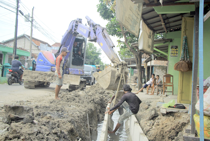 MASA KRITIS: Alat berat melakukan pengangkatan u-ditch di jalan Slamet Riyadi, Rembang, Rabu (14/12). (WISNU AJI/RADAR KUDUS)