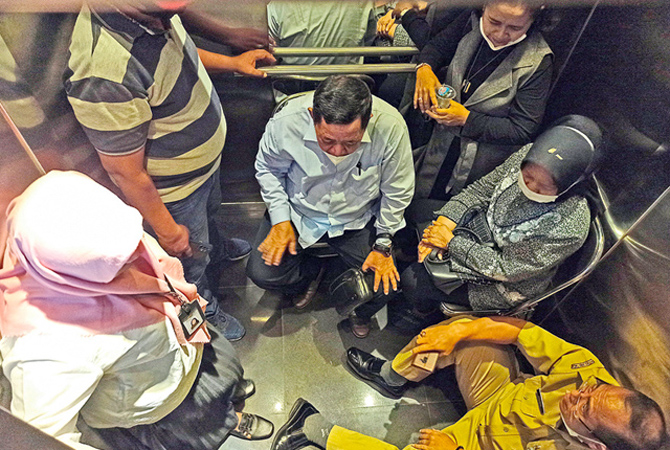 MENUNGGU PERTOLONGAN: Ketua Fraksi PKB DPRD Kota Surabaya Minun Latif (tiga dari kiri) dan teman-temannya berupaya tetap tenang saat terjebak di dalam lift gedung baru DPRD Surabaya, Senin (5/12). (Frizal/Jawa Pos)