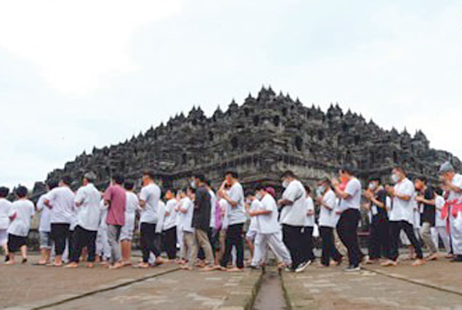 Para peserta Pabbajja Samanera Sementara mengikuti pradaksina dengan mengitari Candi Borobudur Magelang Sabtu (17/12). (Istimewa)