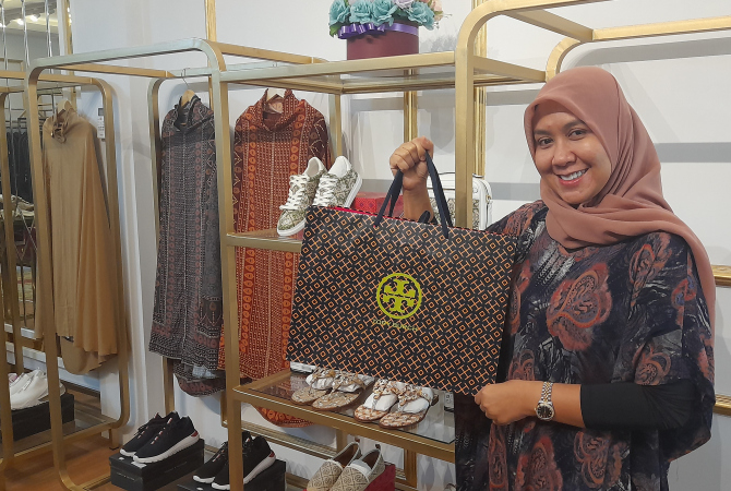 DIMINATI: Dian Aulia, pemilik D.M.A Boutique memperlihatkan salah satu koleksi Tory Burch di butiknya belum lama ini. (NIBROS HASSANI/RADAR KUDUS)