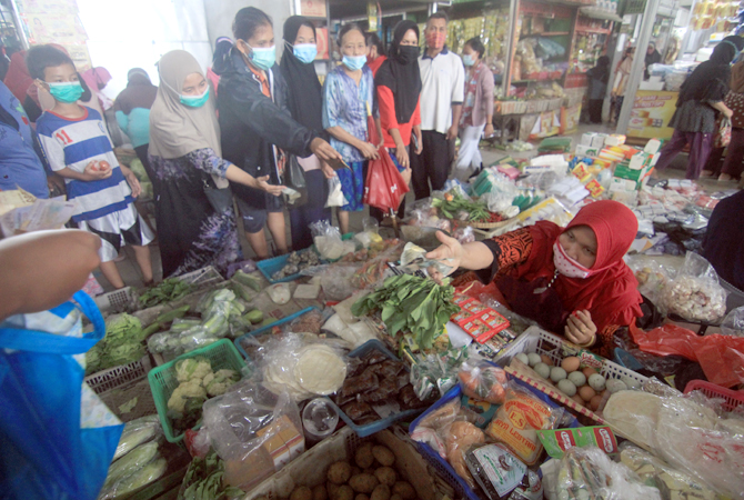 LONJAKAN HARGA: Pedagang di Pasar Bitingan Kudus sedang melayani pembeli. (DONNY SETYAWAN/RADAR KUDUS)